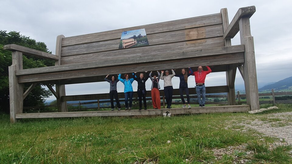 Die Regionalgruppe Allgäu: Sportlich unterwegs auf dem schönen Panoramaweg in Oy-Mittelberg beim Stemmen der XXL-Wanderbank …